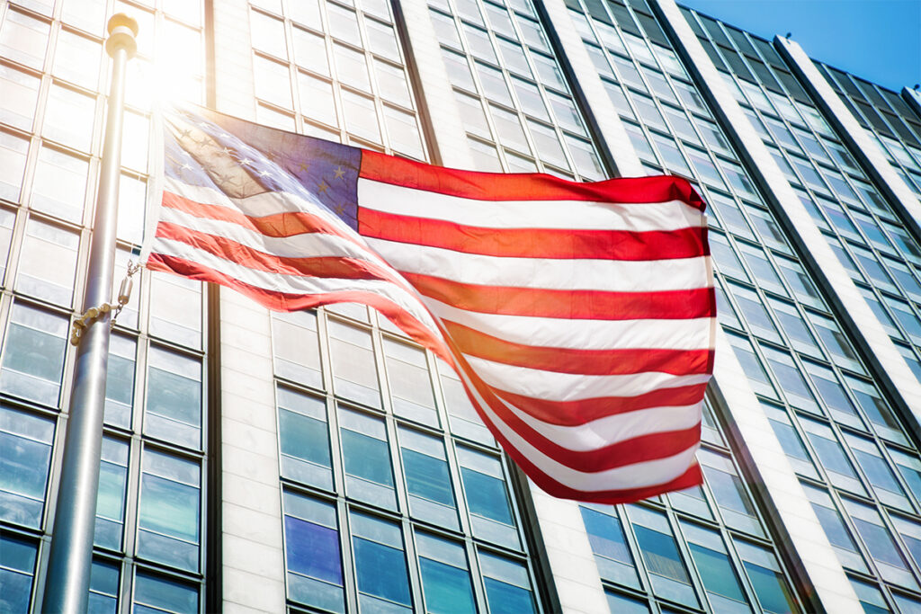Floating American flag in front of office building sun flare