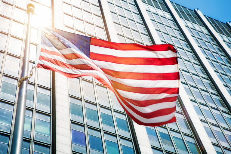 Floating American flag in front of office building sun flare
