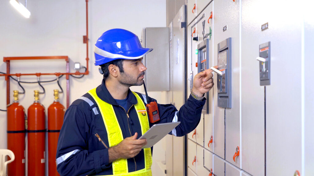An engineer man or worker, people working in electrical room. Power energy motor machinery cabinets with panel in control or server room, operator station network in industry factory. Switchgear